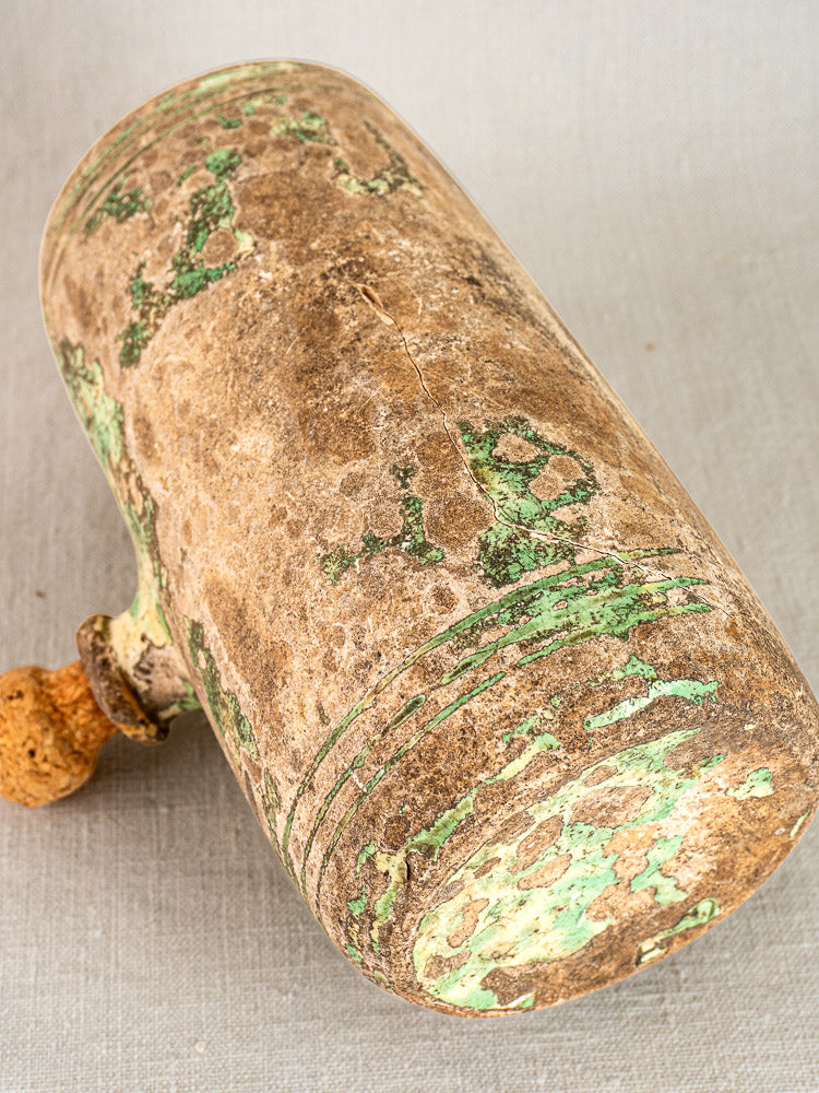 Antique French 18th-century hand-thrown terracotta bouillotte with cork stopper, brown-green patina on light fabric.