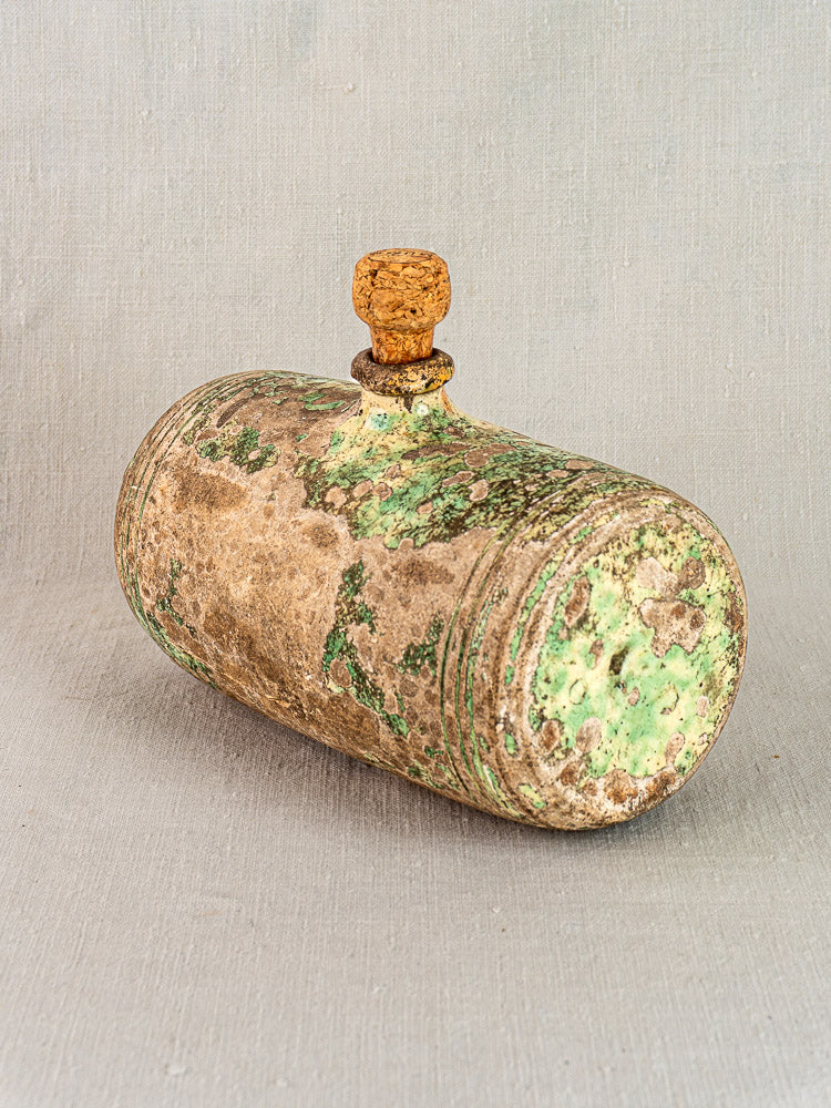 18th-century French terracotta bouillotte with weathered finish and green patina, displayed on a light background.