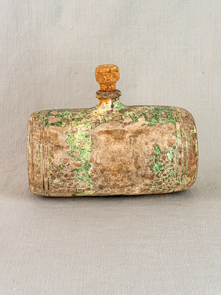 18th-century French terracotta bouillotte hot water bottle with wooden stopper on a plain light gray background.