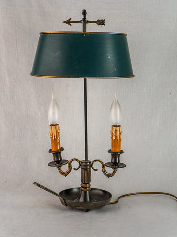 French Bouillotte lamp with green tôle shade, two arms, candle-style bulbs, and arrow finial.