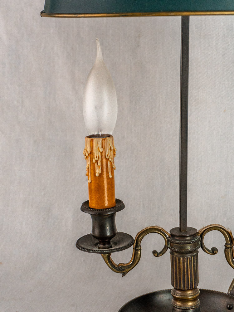 French Louis XVI Bouillotte lamp with vintage green tôle shade, ornate brass body, and candle flame bulb.