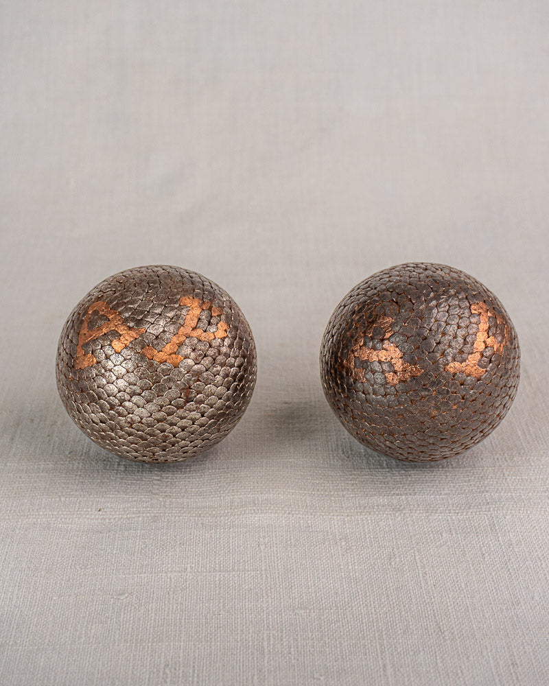 Pair of early 20th century antique French pétanque boules cloutées, rustic brown, on light gray background. Set of five.