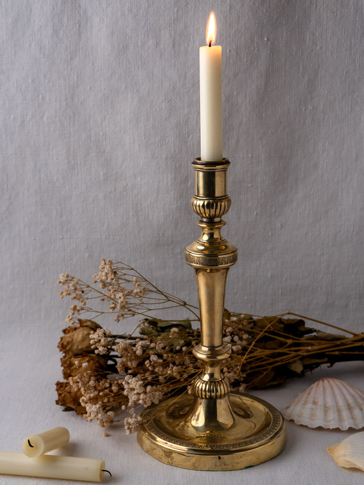 Antique French Empire Palmette brass candlestick with ornate detailing on a round base.