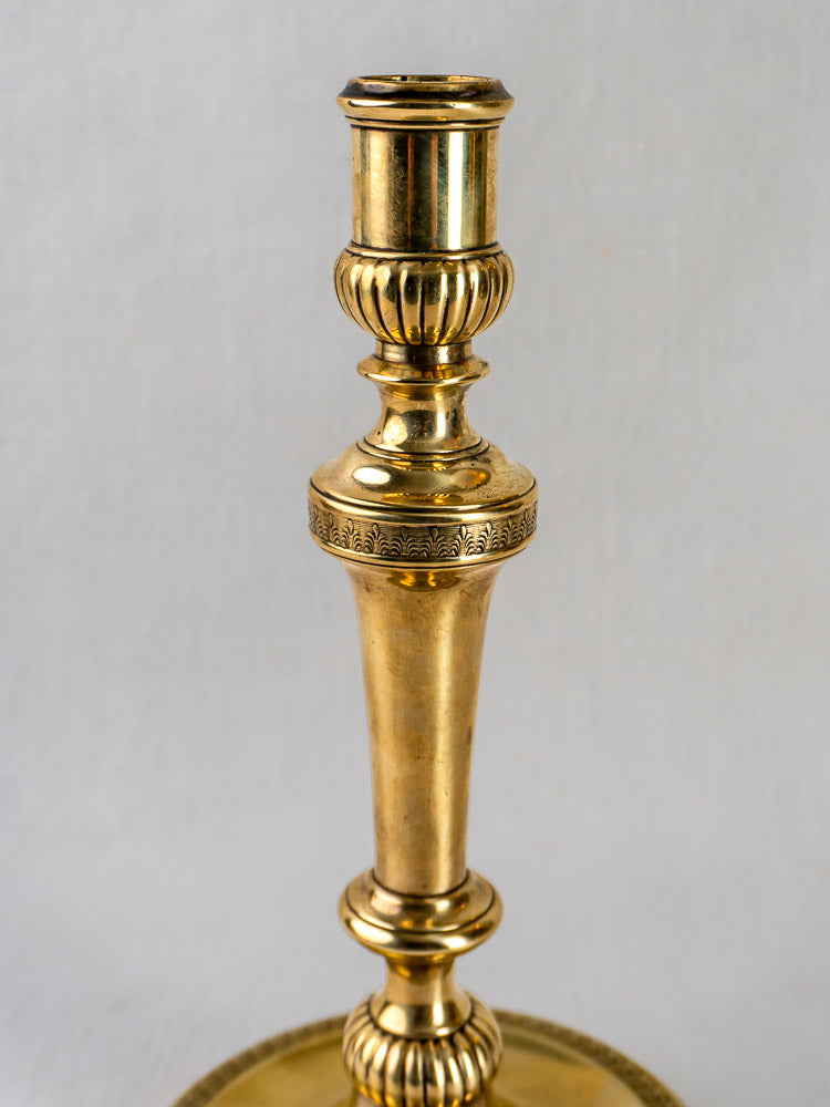 Empire Palmette Brass Candlestick with polished finish and ornate details, plain light background.
