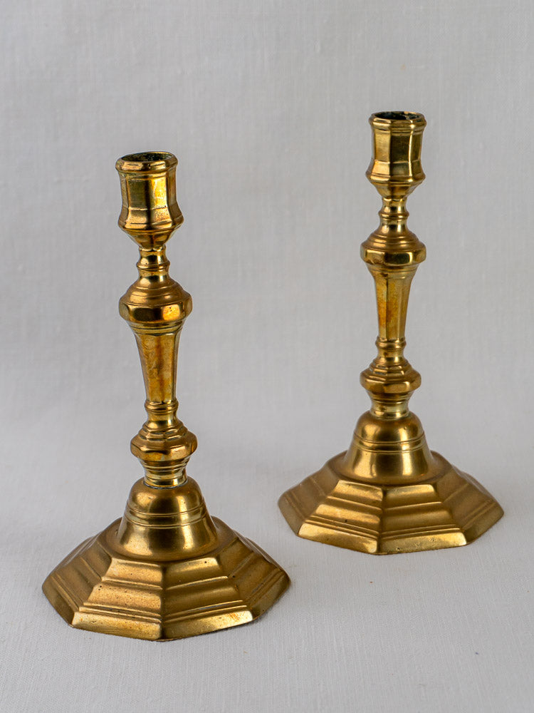 Pair of antique French Louis XV brass candlesticks with hexagonal bases and ornate stems.