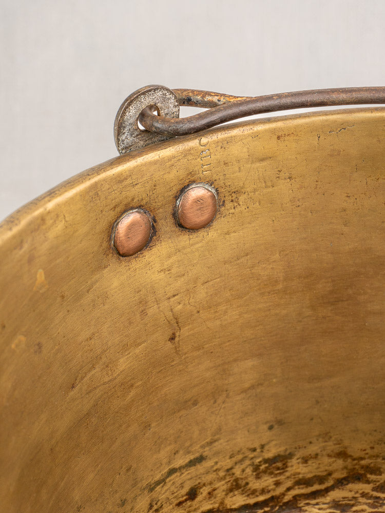 Antique French brass jam pan rim with two rivets, handle attachment, and patinaed, timeworn surface.