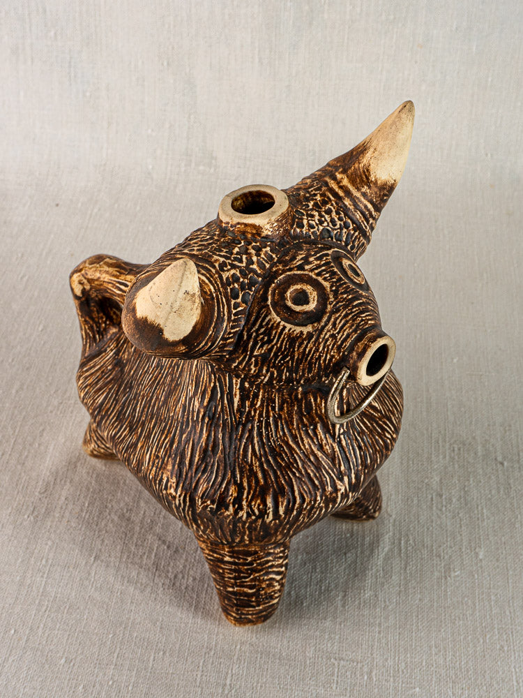Mid-century French bull pitcher in textured brown ceramic with exaggerated horns, round eyes, and a circular back opening.