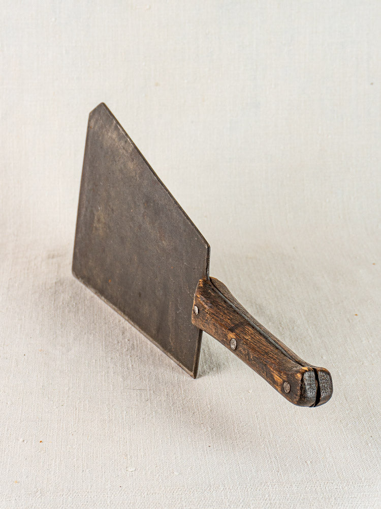 Antique French butcher cleaver with wide hand-forged blade and timeworn wooden handle, mid 19th century.