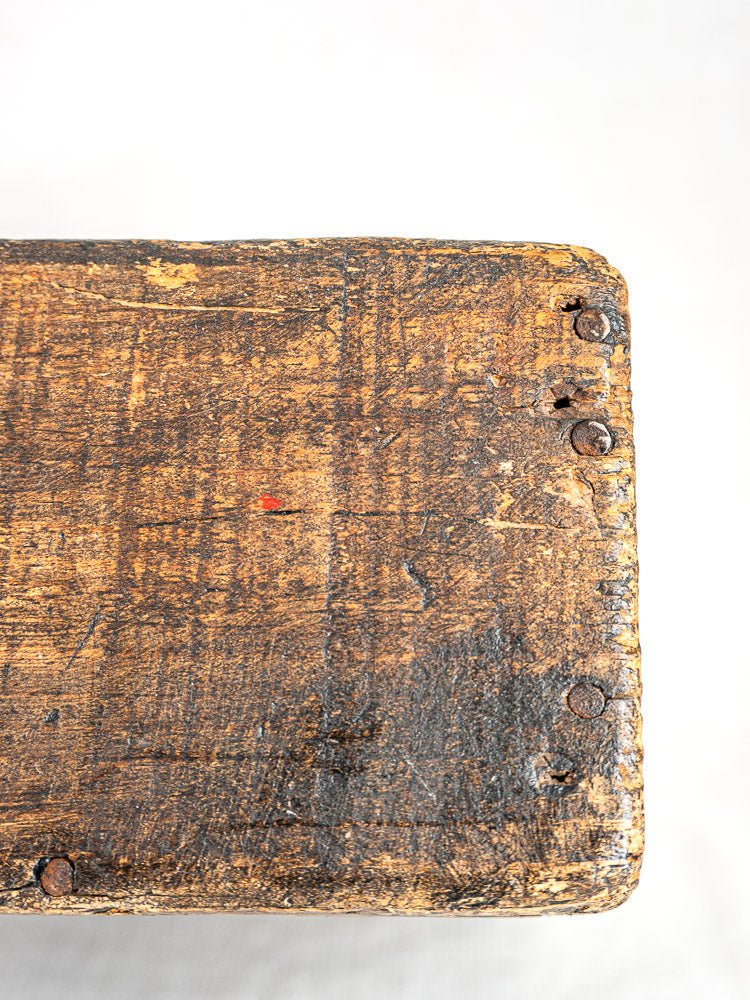 Antique French oak tool tote corner with hand-forged nails, worn wood, and aged patina on white.