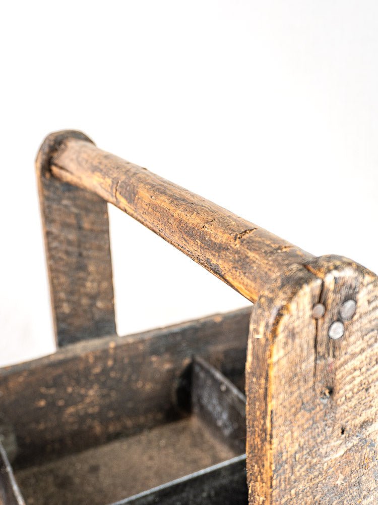 Antique French oak tool tote handle with visible grain, worn texture, and hand-forged nails on white background.