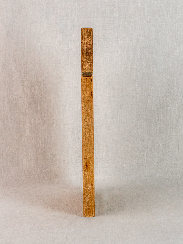 Antique French hardwood cutting board, 19th century, upright on neutral light fabric background.