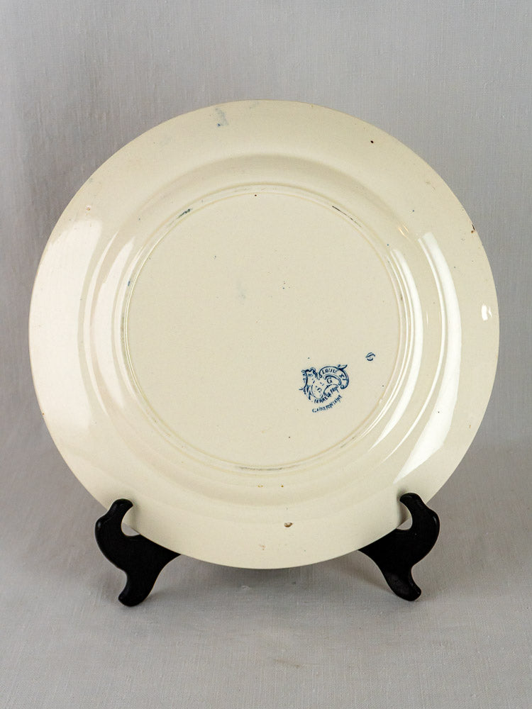 Cream-colored French Terre de Fer Louis XV serving platter with blue maker’s stamp, on black display stand.