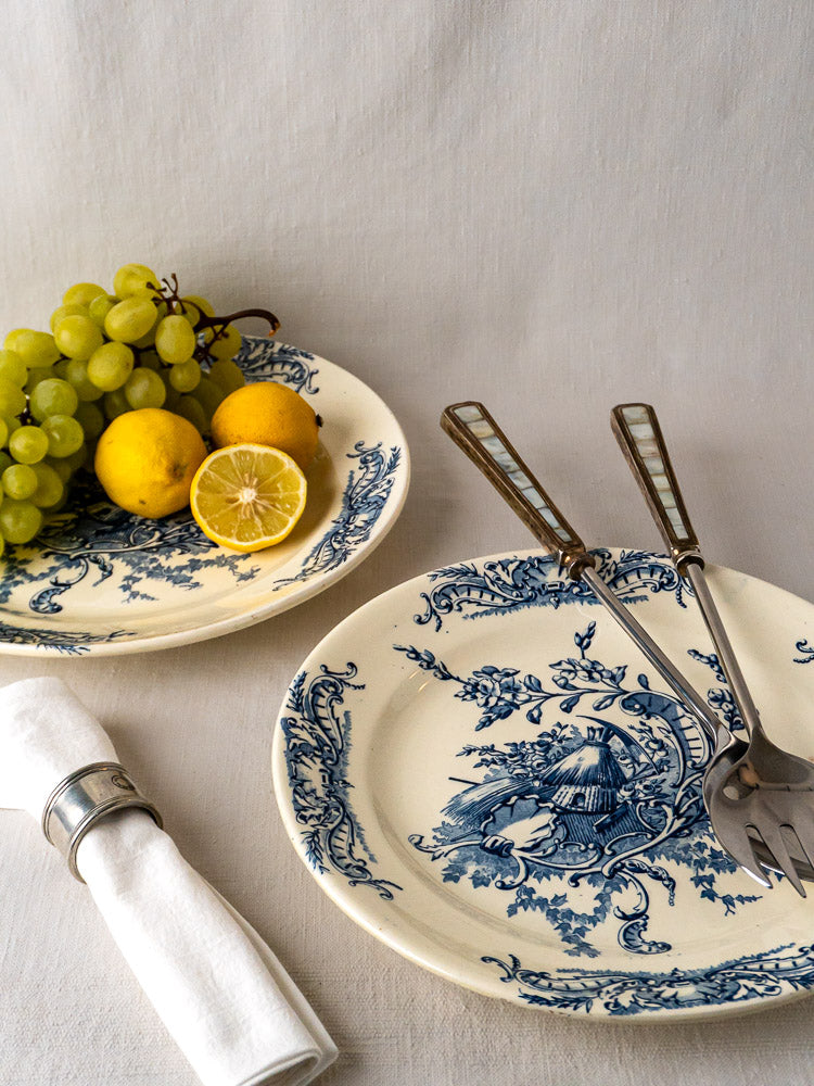 Pair of antique French blue and white Terre de Fer serving platters on a white cloth.