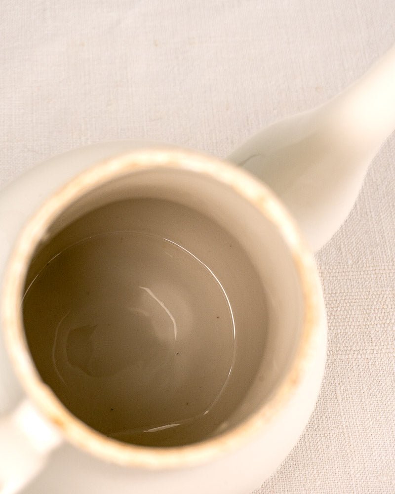 French Limoges coffee pot in white Frugier Aluminite porcelain on textured light fabric.
