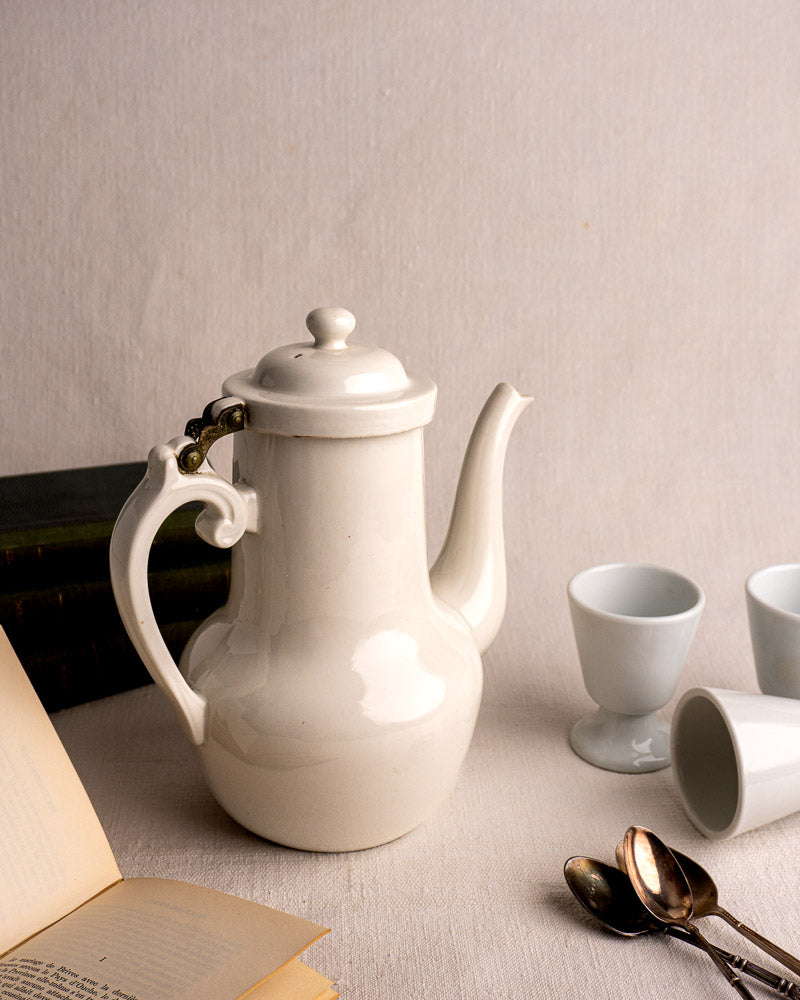 French Limoges Frugier aluminite porcelain coffee pot with curved spout, ornate handle, and hinged lid.
