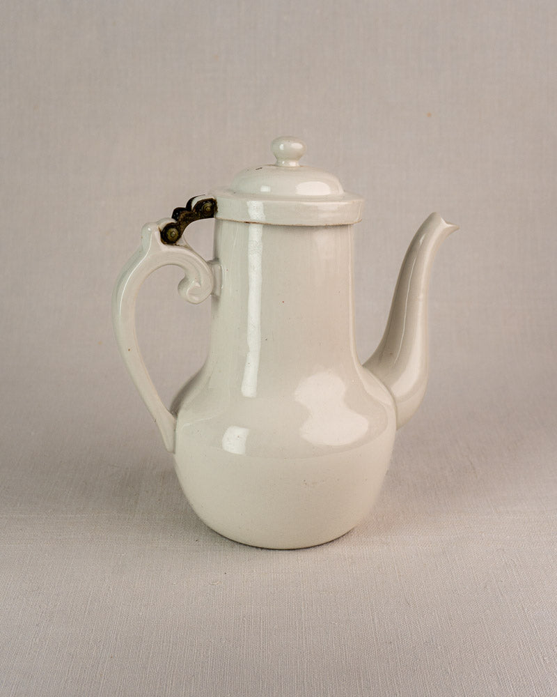 French Limoges Frugier aluminite porcelain coffee pot with curved spout, ornate handle, and hinged lid.