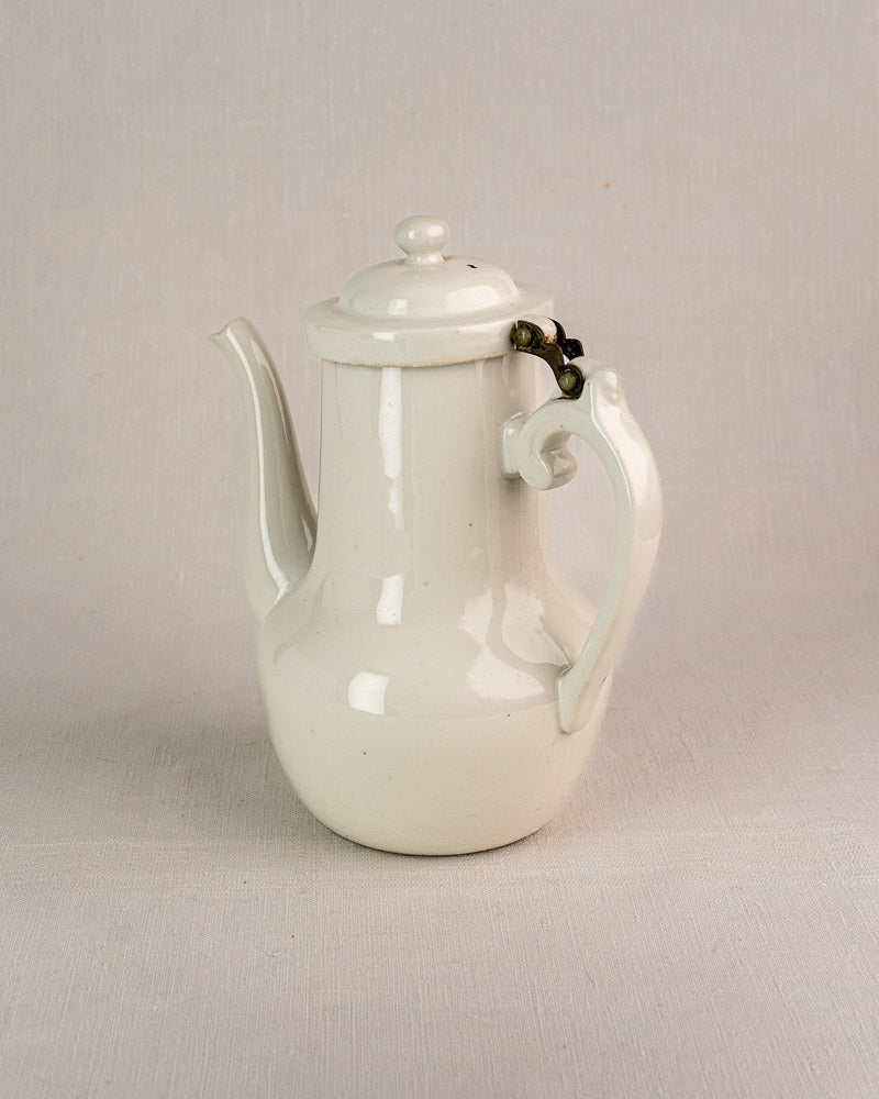 Early 20th-century French Limoges Frugier coffee pot in white Aluminite porcelain on gray surface.