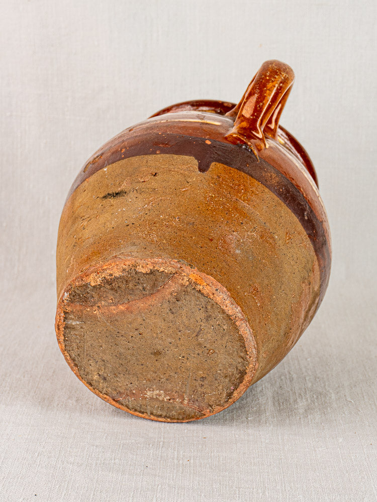 Large antique French confit pot, mid-19th century, brown glaze, yellow slipwork, single handle, unglazed base.