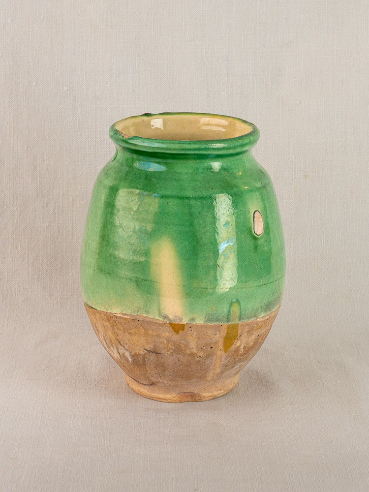 Antique French confit pot, circa 1900, rounded terracotta with green upper glaze and unglazed brown base on a light background.