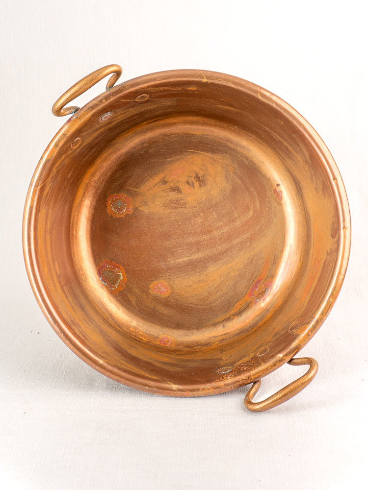 Pair of late 19th century French copper basins, round and shallow with twin handles and aged patina, sold as nesting set.