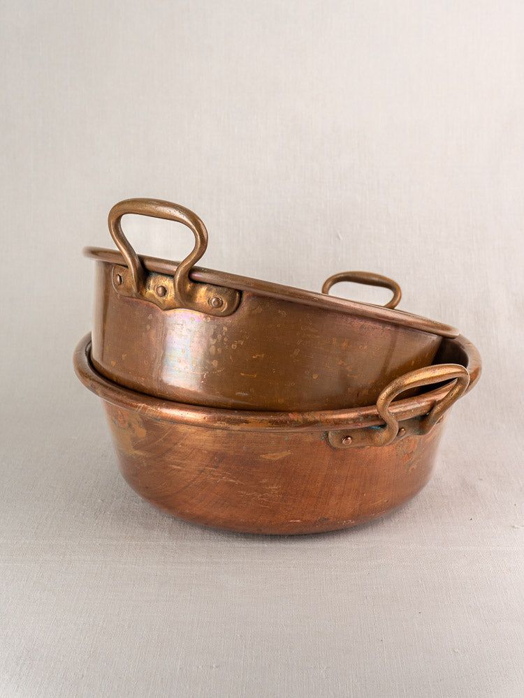 Nesting pair of late 19th-century French copper basins stacked on a light background.