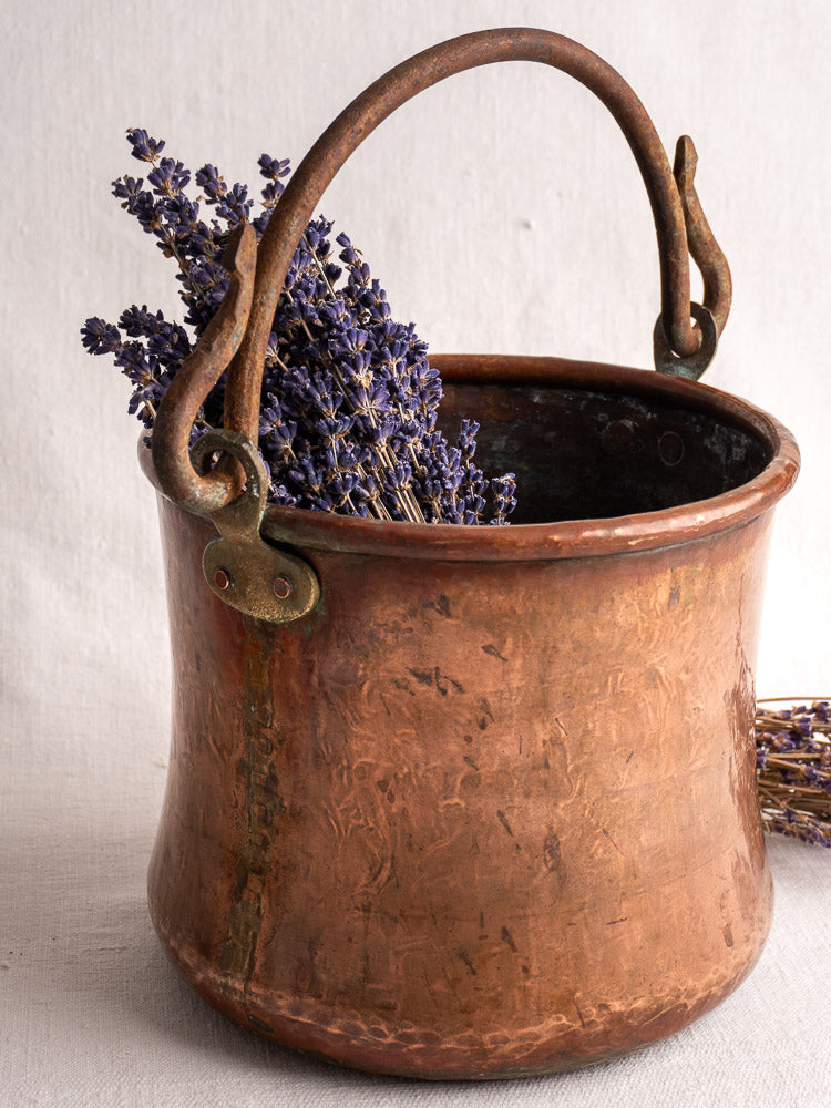 Antique French hammered copper bucket with wrought iron handle, filled with dried lavender.