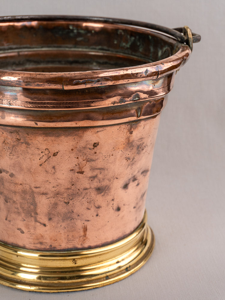 Antique French copper champagne bucket with brass base and metal handle, late 19th century, on a plain light background.