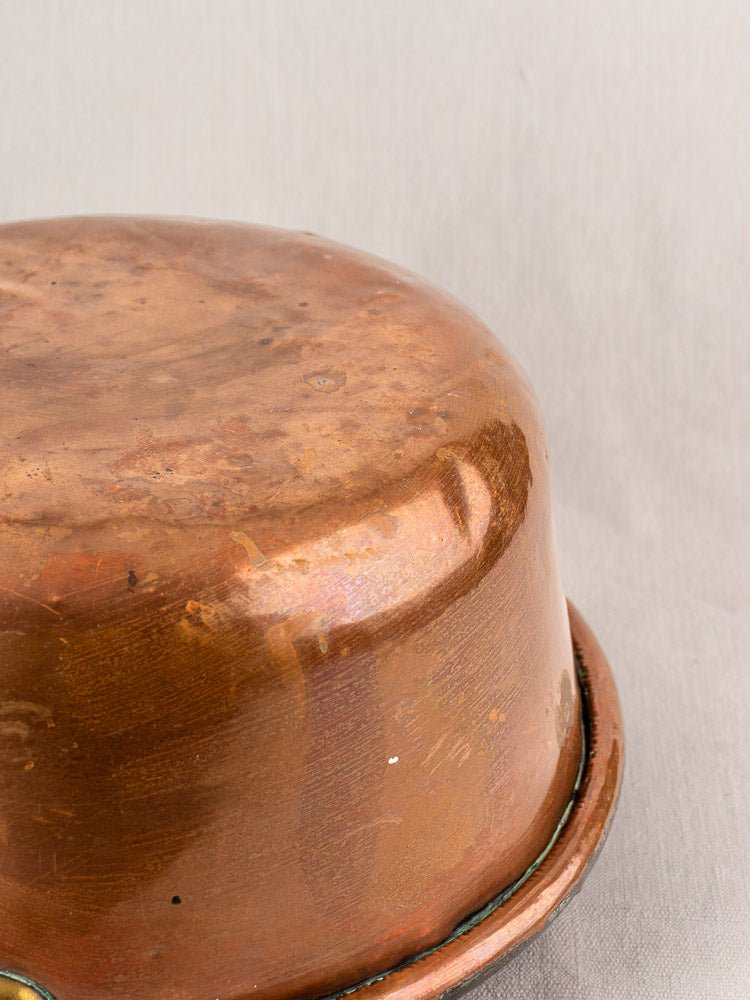 Antique French copper jam pan with brass handles, late 19th century, dented and polished.