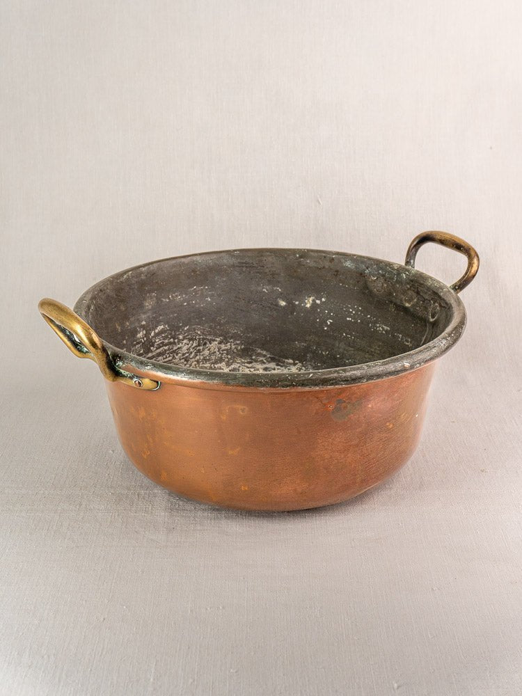 Late 19th century French copper jam pan with brass handles, worn interior, tarnished patina.