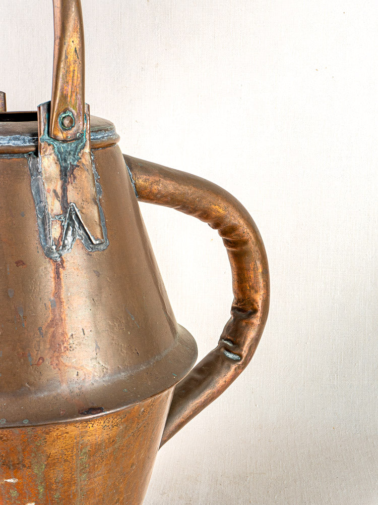 Antique French copper watering can by Jean Goardère with curved handle, aged patina.