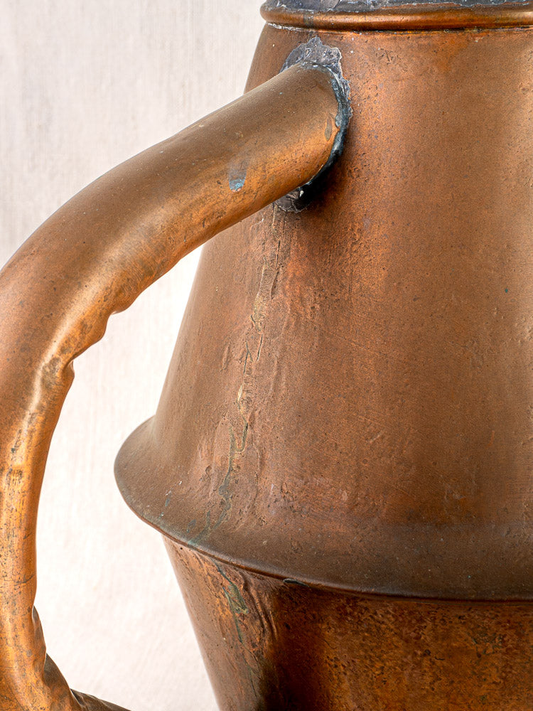 Vintage French copper watering can by Jean Goardère with curved handle, patina, and welded joints.