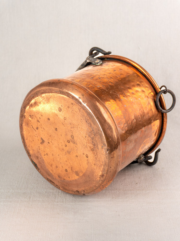 Antique French copper hanging buckets with wrought iron handles, aged patina and rings, on a light grey background.