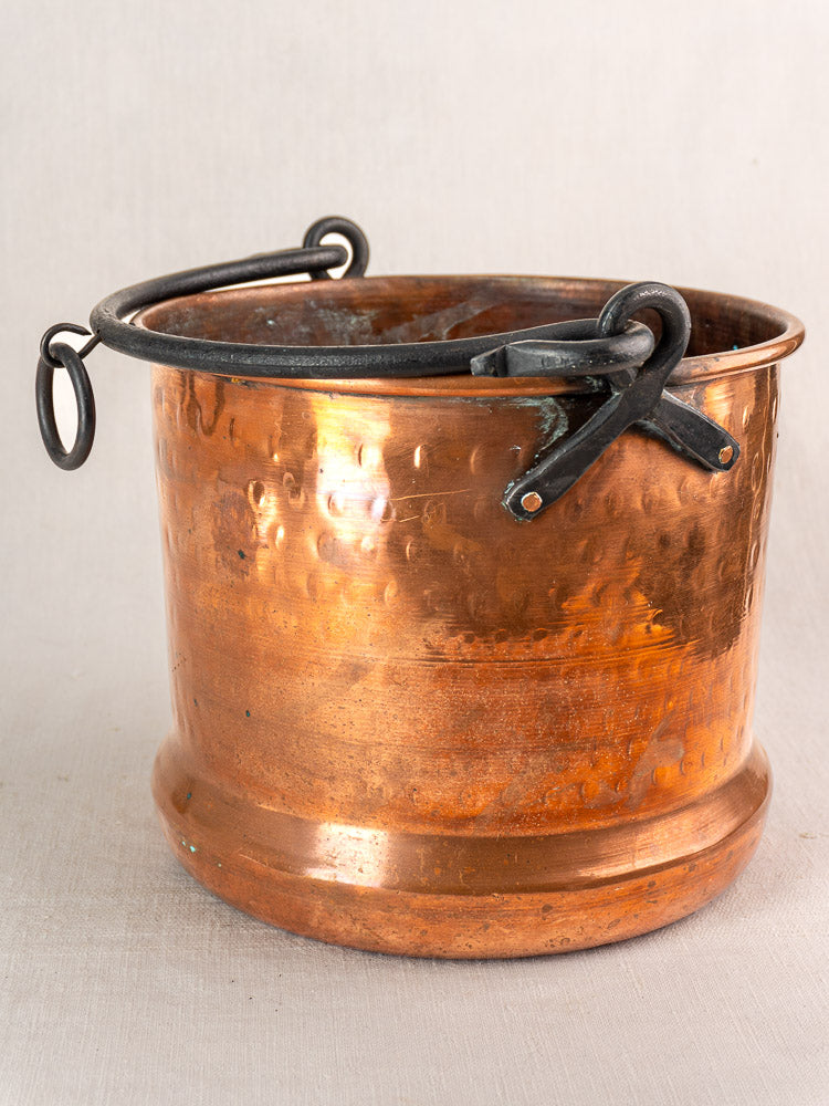 Pair of 19th-century French copper hanging cauldrons with round hammered bodies and black metal handles.