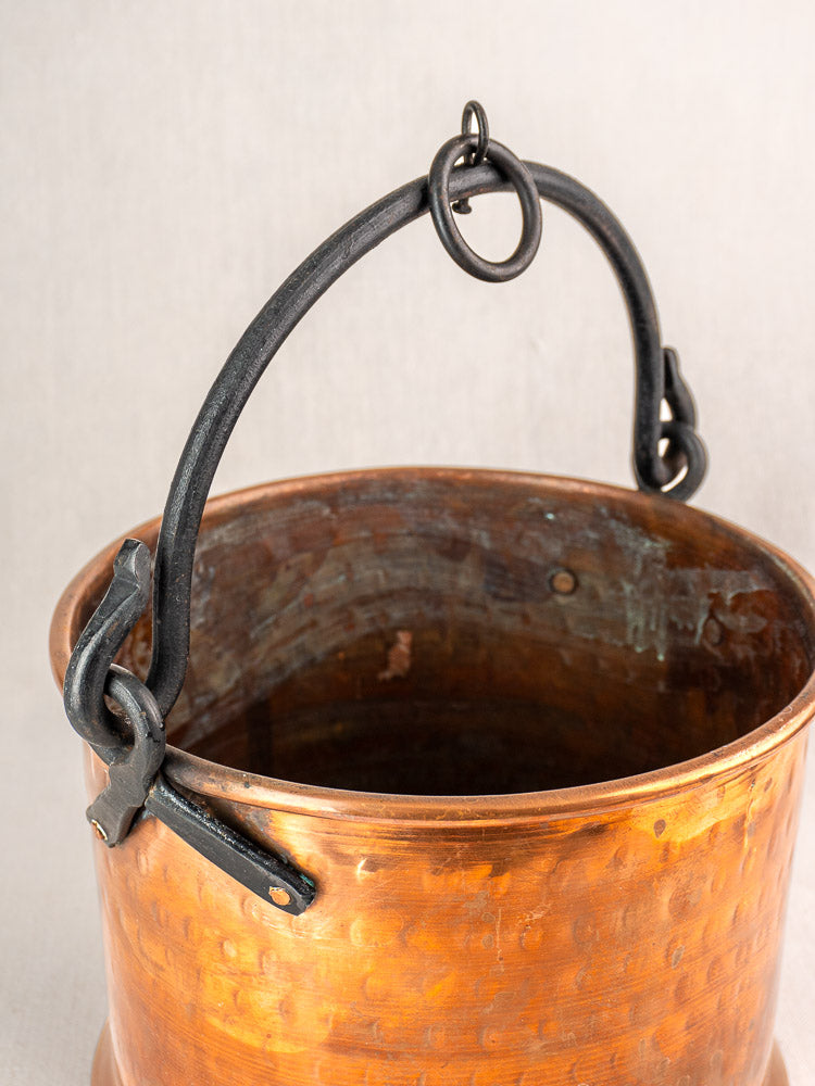 Pair of 19th-century French copper cauldrons with curved handles, ring attachments, and aged interiors.