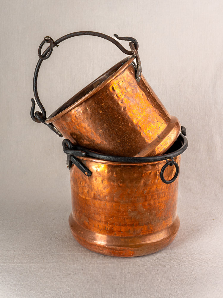 Pair of 19th-century French copper hanging buckets with black metal handles, nested on a neutral background.