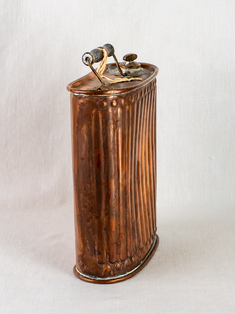 Antique French copper bouillotte hot water bottle with fluted design, screw cap, and top handle.