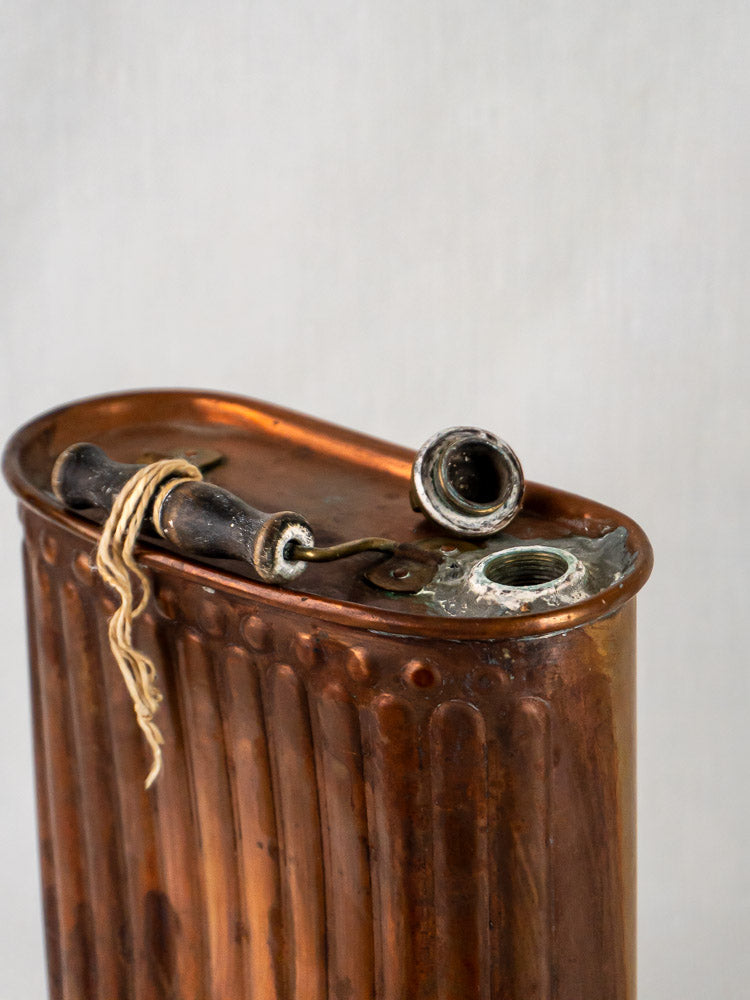 French fluted copper bouillotte hot water bottle with cap, shown upright on light background.