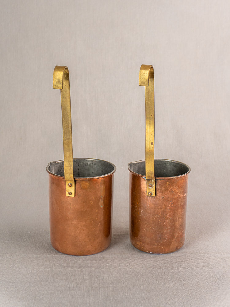 Set of five late 19th-century French copper measures with brass handles, displayed side by side on a neutral background.