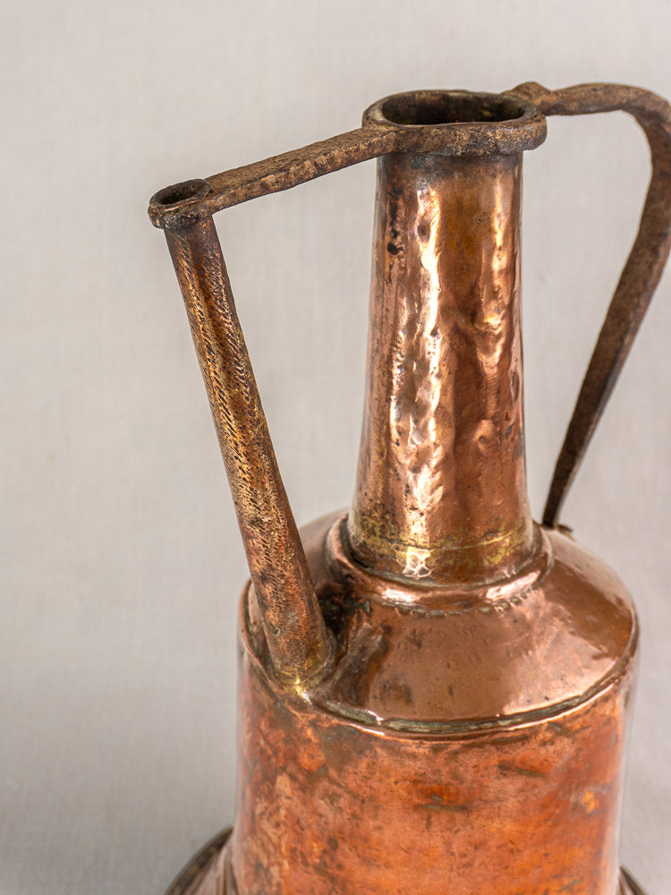 19th-century French copper water jar with hammered finish, twin iron handles, aged patina, on a light background.