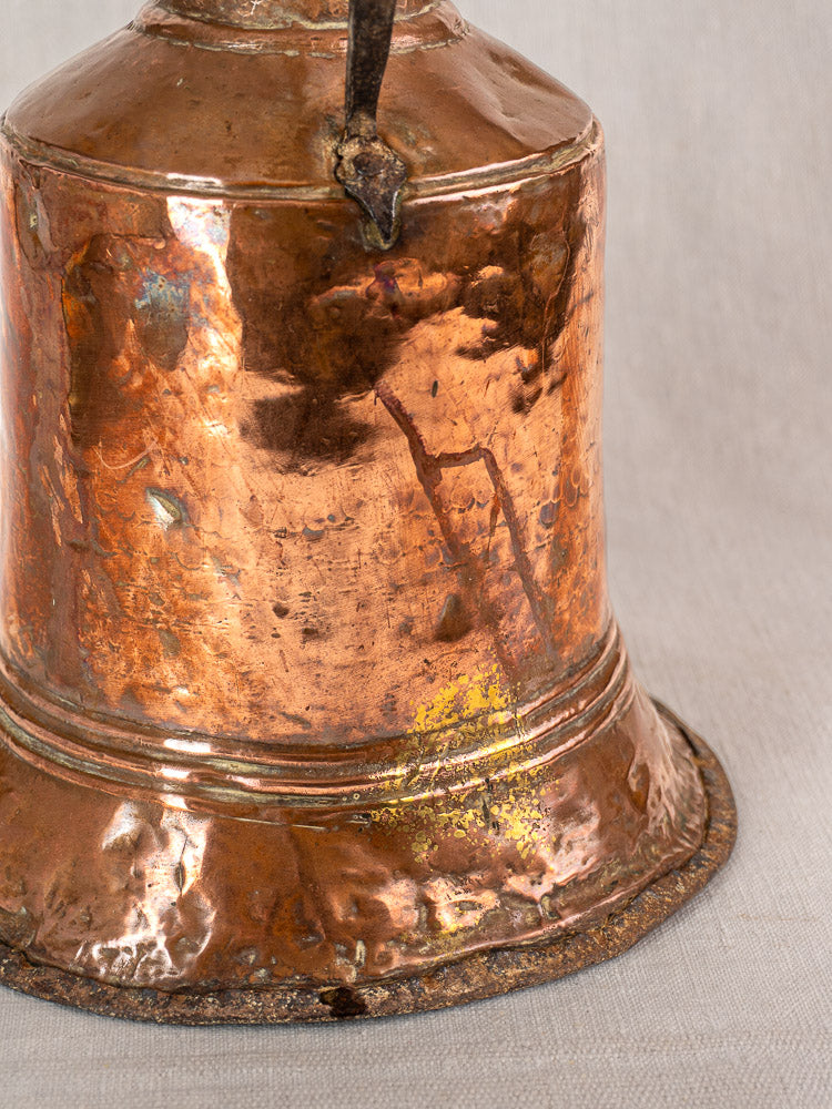 Antique French copper water jar with hammered surface, twin iron handles, and aged patina on light gray textured background.