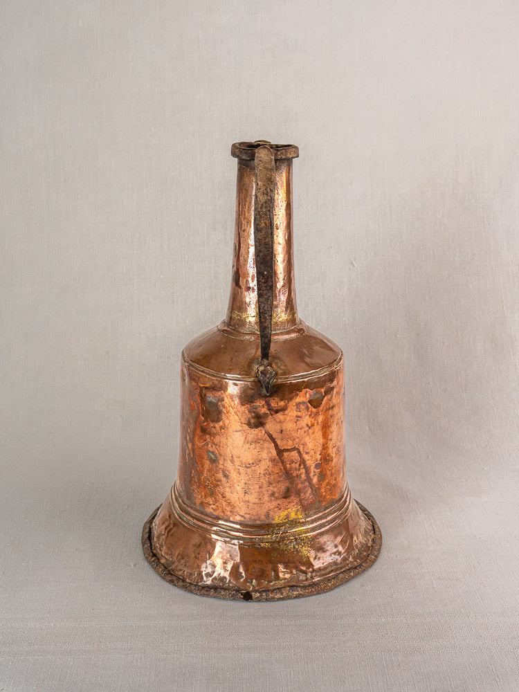 19th-century French hammered copper water jar with twin iron handles on a neutral gray fabric background.