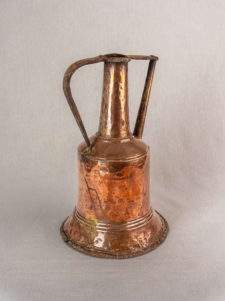 19th-century French copper water jar with hammered finish and dual iron handles on a light gray background.