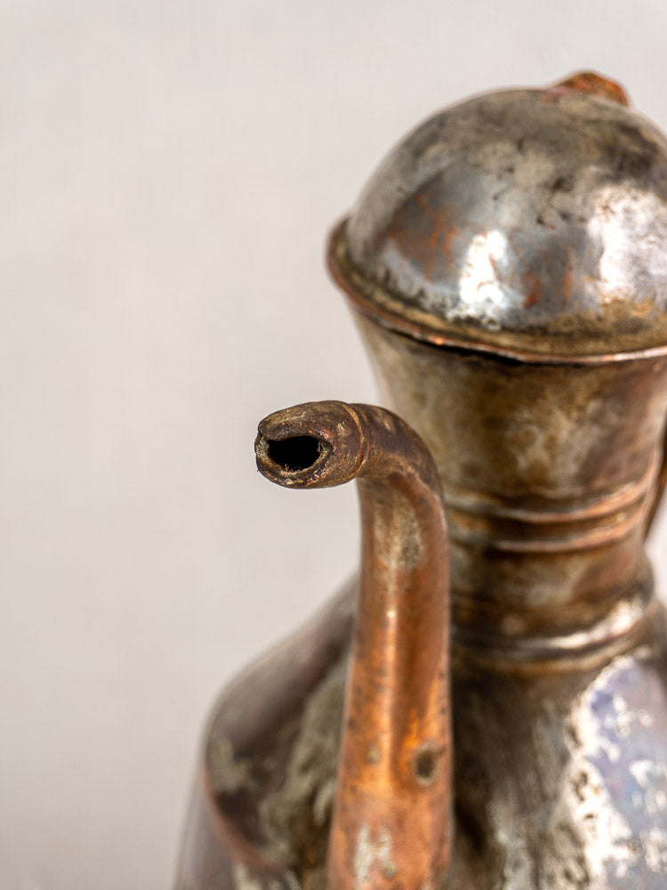 Antique French copper oil pouring jug, 19th century, hand hammered with curved spout and rounded lid, tarnished patina.