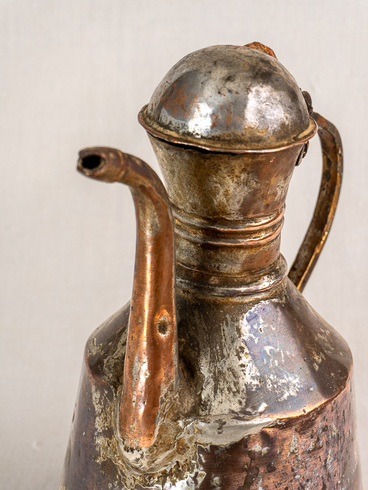 Antique French hand-hammered copper oil jug with handle and spout, showcasing tarnished vintage patina.