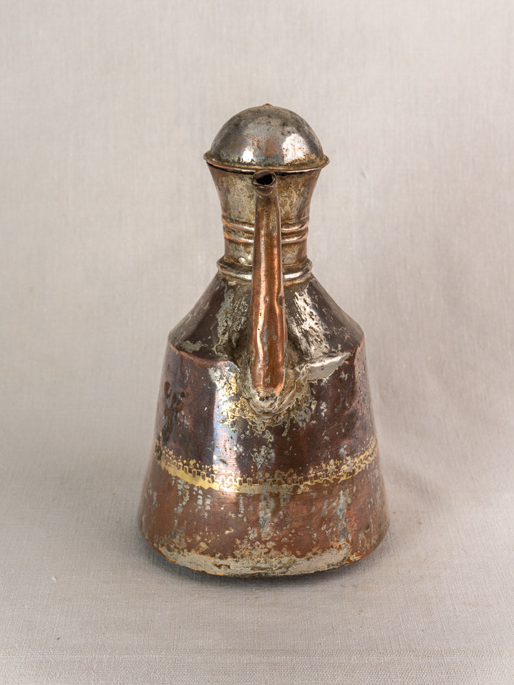 Antique French copper oil pouring jug with hand-hammered finish, patina, domed lid, spout, and decorative bands.