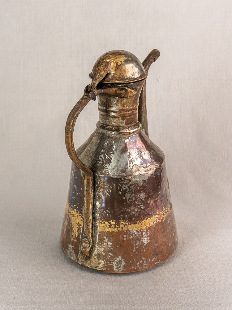19th century French copper oil pouring jug, hand hammered with domed lid, curved handle, and decorative band.