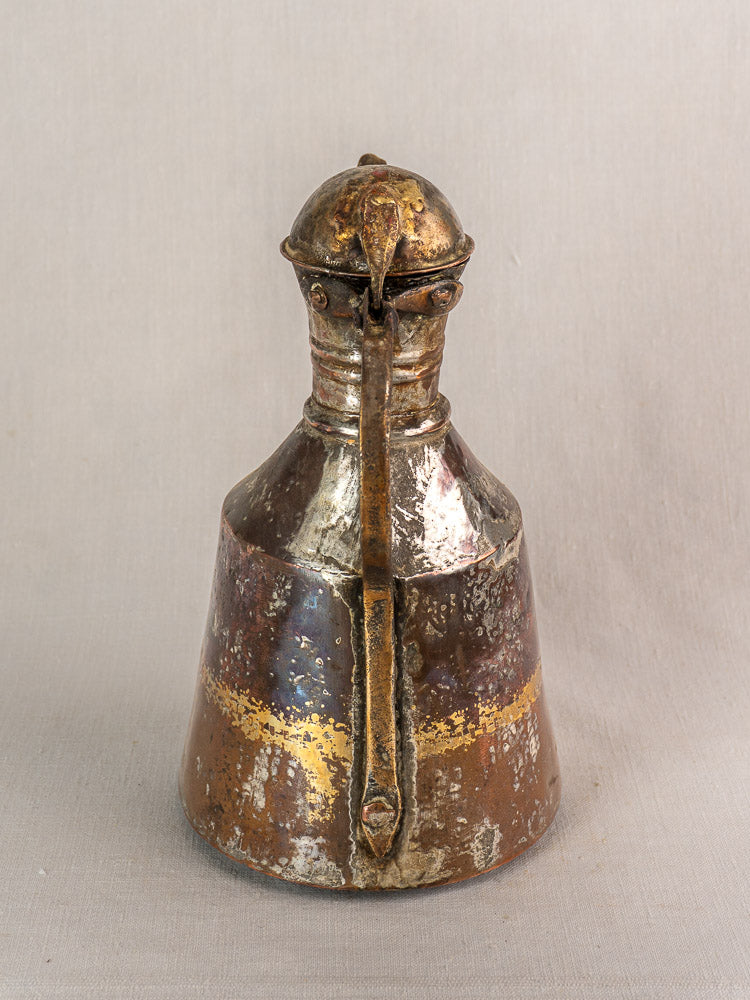 Antique French 19th-century hand-hammered copper oil jug with rounded top, central ridge, and aged patina.