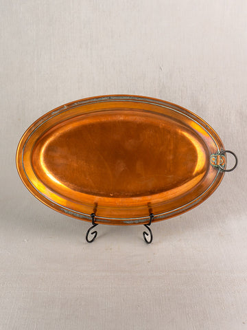 Antique French copper platter, oval tinned dish with metal rim and hanging ring, displayed on a black stand.