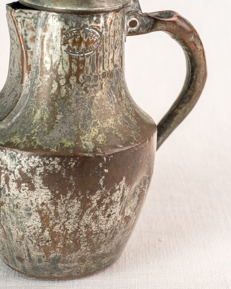 Antique French copper pitcher by Allez Frères with hinged lid, curved handle, and visible wear.