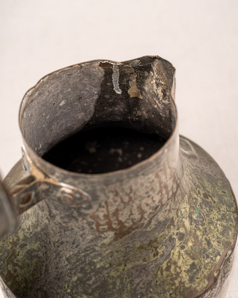 Antique French copper pitcher (coquemar) with hinged lid, worn patina, and dented rim.